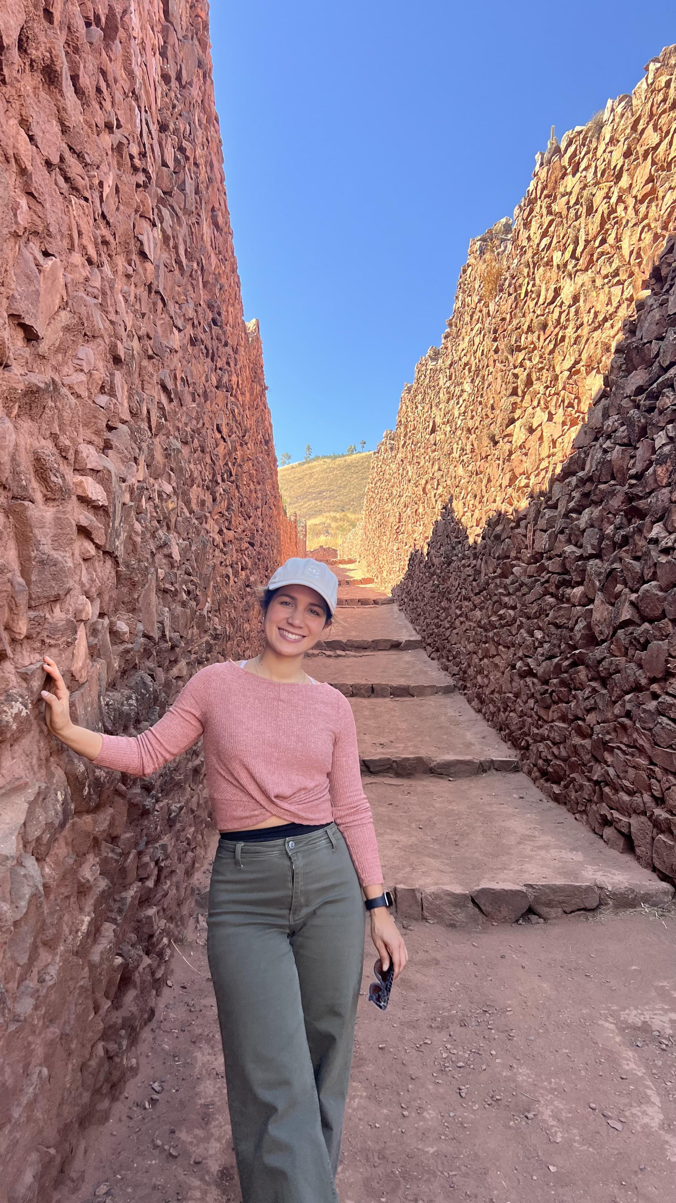 Astrid Sánchez sonriendo al aire libre, en un paseo entre muros de piedra